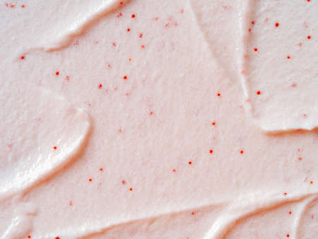 Scrub smears. Texture cosmetic scrub for face and body with abrasive particles in pastel pink color. Exfoliating body polish texture as cosmetic gommage background with copy spaceの写真素材