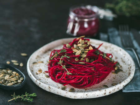 Beetroot pesto or hummus. Homemade beet pesto sauce in glass jar and fresh thyme on dark black background. Copy space for text. Ideas and recipes for healthy vegetarian detox diet foodの写真素材