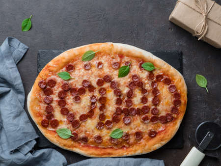 Fathers day background. Pepperoni pizza with i love dad lettering and gift box on black table. Father day concept, recipe and idea. Top view or flat-lay. Copy space for text.の写真素材