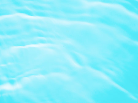 Ripple water texture on blue pool background. Shadow of water on sunlight. Mockup for product, spa or travel background. Marble blue water surface as wallpaper backgroundの写真素材