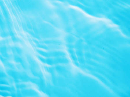 Ripple water texture on blue pool background. Shadow of water on sunlight. Mockup for product, spa...