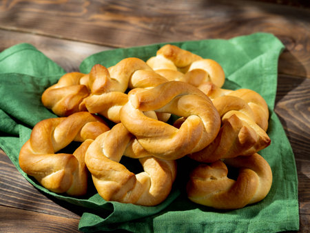 Taralli twist on wooden background. Typical italian ring-shaped or doughnut-shaped biscuit cookies or appetizers for wine Taralli or Taralle. Copy spaceの写真素材