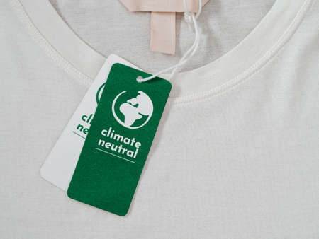 Carbon neutral t-shirt, Label Climate neutral on new clothes. Carbon neutral label concept in apparel, fashion industry. Ethical consumption.Increasing awareness for customers - carbon footpintの写真素材
