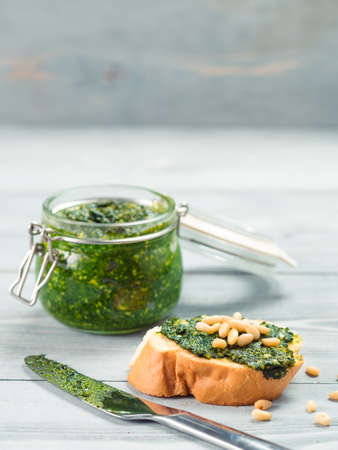 Close up view of baguette bread with fresh basil pesto sauce on gray wooden table. Copy space.の写真素材