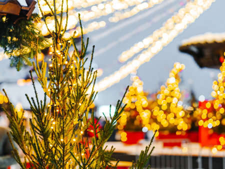 Festive decorated christmas street with winter fair and food market in snowy city. Traditional winter street market and illuminated christmas tree. Copy spaceの写真素材
