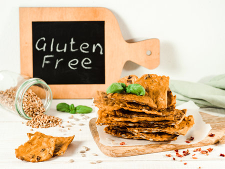 Gluten-freen crispbreads made from buskwheat flour. Green buckwheat flour, smoked paprika, sunflower seeds is ingredients for this homemade baked crisp bread. Idea recipe snacks, gluten-free conceptの写真素材