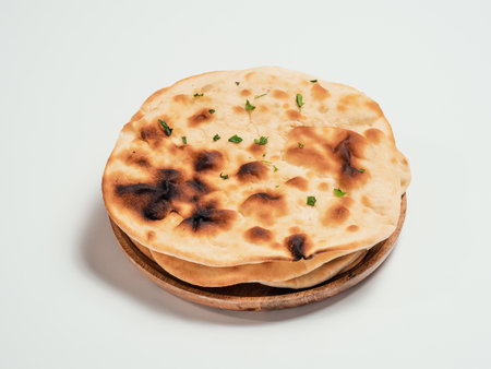 Fresh naan bread on plate isolated on white background. Stack of several perfect naan flatbreads on white.の写真素材