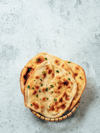 Fresh naan bread on gray cement background with copy space. Top view of several perfect naan flatbreads. Verticalの写真素材