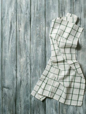 Gray wooden table with linen kitchen towel or textile napkin flat lay. Blue tablecloth on old gray wood tabletop. Copy space for text. Can use as mock up for design. Vertical.の写真素材