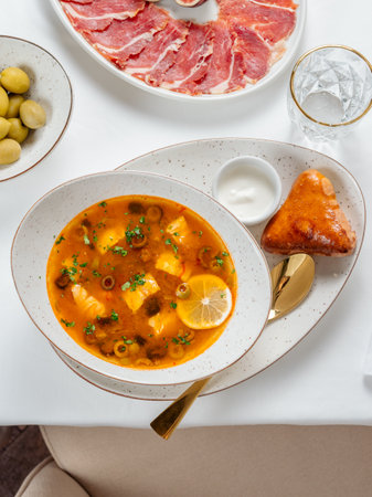 Solyanka soup with meat and olives garnished with a slice of lemon. Traditional Russian meat soup...