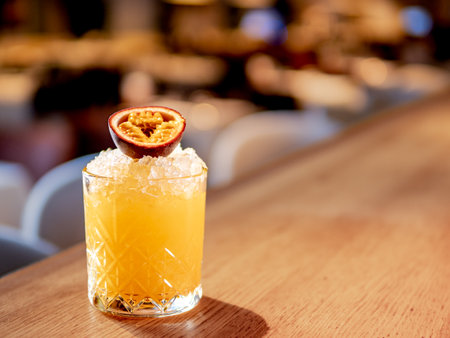 Yellow old-fashioned refreshing cocktail with whiskey and crushed ice on bar counter. Alcohol or non-alcohol cold cocktail decorated passion fruit. Copy space.の写真素材