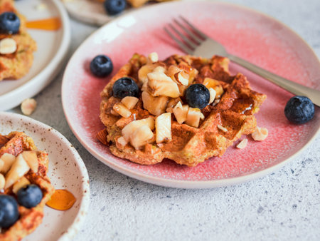 Easy healthy gluten free oat waffles with copy space. Appetizing homemade waffles with oat flour decorated blueberries, on plates over light gray cement backgroundの写真素材