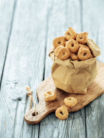 Traditional italian snack taralli or tarallini in paper bag over old gray wooden table. Rustic shot of taralli appetizer with copy spaceの写真素材