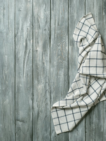 Gray wooden table with linen kitchen towel or textile napkin flat lay. Blue tablecloth on old gray...