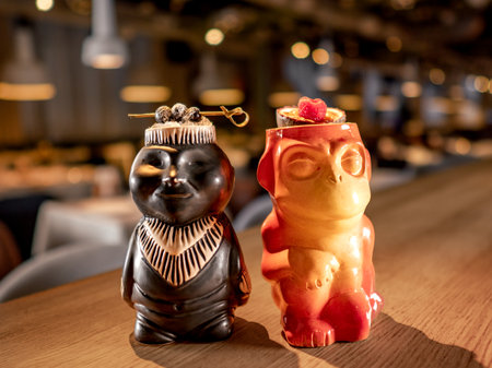 Authentic Tiki Drink Cocktails. Two tropical tiki cocktails on bar counter. Tiki cocktails on bar in night club or restaurant interiorの写真素材