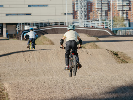Two boys riders on BMX Race made from soil and sand. Adrenaline-Pumping Dirt BMX Race Track. Extreme sport and bicycling conceptの写真素材