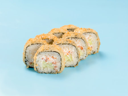 Studio photography of philadelphia roll with cucumber and salmon wrapped in nori. Isolated on solid light blue background. Sushi Perfection with tempura rollの写真素材