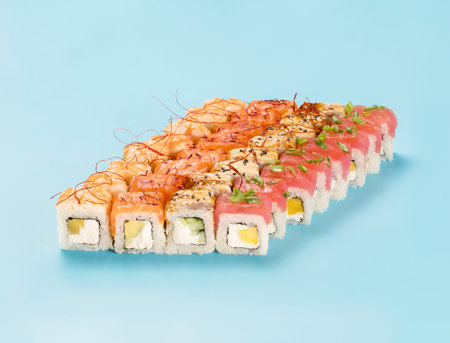 Philadelphia Roll Set with mango, cucumber and avocado, wrapped in perfect seasoned sushi rice and fresh salmon, tuna, shrimp and smoked eel, decorated chili threads. Isolated on light blue backgroundの写真素材