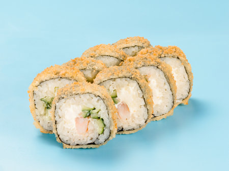 Studio photography of Maki roll with cucumber and shrimp wrapped in nori. Isolated on solid light blue background.の写真素材