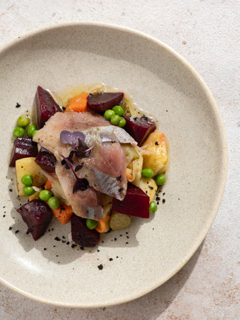 Restaurant dish with fish snack. Salted herring, potatoes, beets, carrots, green peas decorated...