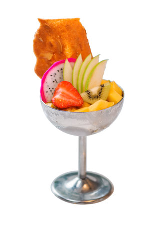 Tropical Paradise sorbet with grapefruit, mango, passion fruit decorated with fresh fruit and crispy tuile cookies isolated om white background. Tropical ice cream in metal sundae bowlの写真素材