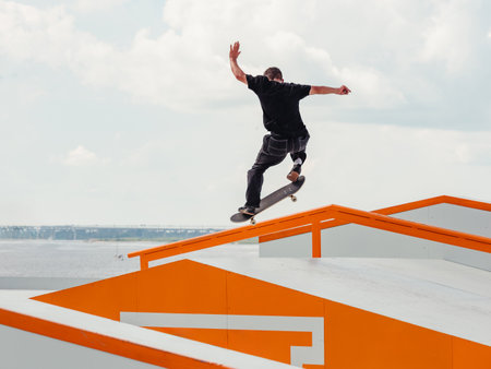 Latino Boy doing skateboard trick on rail in skatepark. Professional sportsman grinding on skateboard in outdoor park. Faceless unrecognizable Latin skater doing Manual Grind trick. Skate backgroundの写真素材