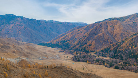 View from the Chike-Taman pass on the Chuysky tract. Mountain landscape in the Altai Republic. Chike-Taman pass in Altai mountains. Autumn mountains with green and yellow trees. Autumn landscapeの写真素材