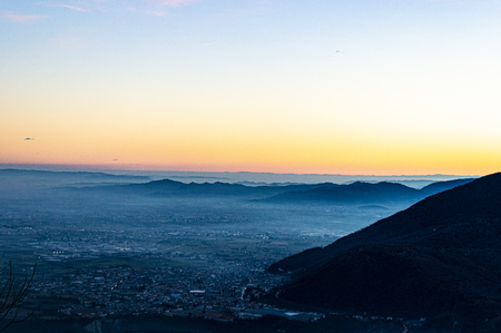 beautiful sunset over the Po valley, with vicenza and the euganean hills in the background, a haze covers the whole scene making it more etherealの写真素材