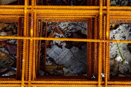 Rusted and stacked metal mesh on the sand forms a relaxing and peaceful orange geometryの写真素材