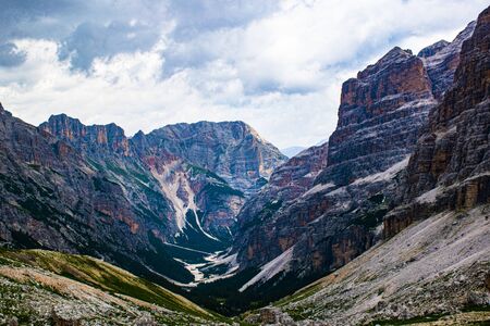 walking on the dolomitic paths protected by the  attracts extraordinary panoramas between peaks of rock, white clouds on blue skies, hiking among the rocks near Cortina D'ampezzo, Italyの写真素材