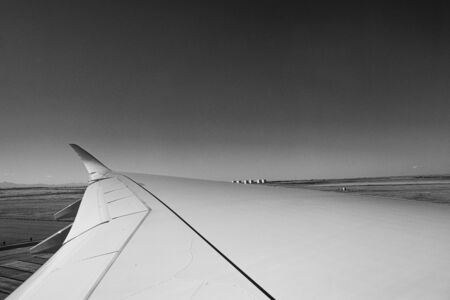 photo of the horizon with the wing of a plane in black and whiteの写真素材