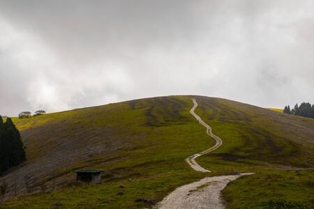 path meanders through the fields on the mountains of the Asiago plateau near Vicenza, Italy.