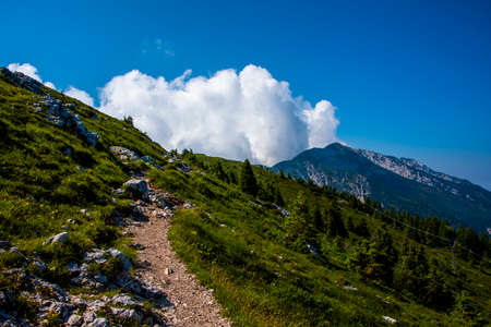 white clouds on the tops of the Venetian pre-Alps on the chain of Monte Baldo on Lake Garda, Malcesine, Verona, Italyの写真素材