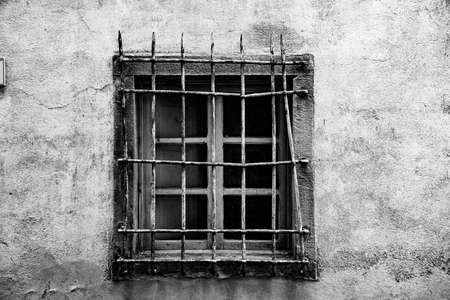 photograph of an old grunge black and white window with rusty grilleの写真素材