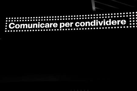 lettering: communicate to share, in white backlit on a black background