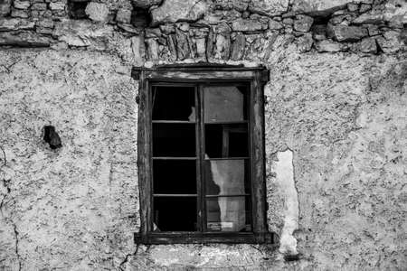 old wooden window with broken glass and old peeling wall from time in Fondo, Valle di Non in Trento, Italyの写真素材