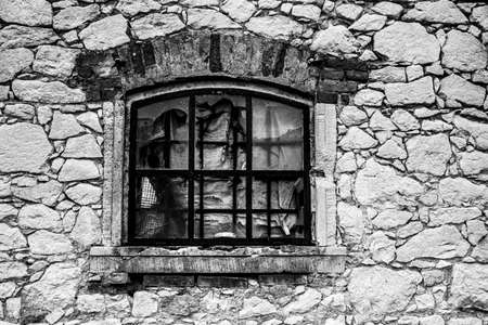 vintage window of an old barn with broken glass and rusty railingの写真素材