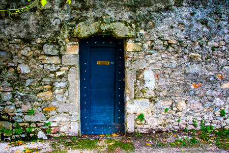 blue door on the ancient stone walls of Vittorio Veneto, Treviso, Veneto, Italyの写真素材