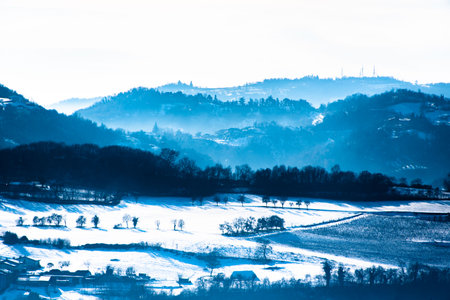 fog in the snow in the hills of Sovizzo with small snow-covered villages in Vicenza, Italyの写真素材