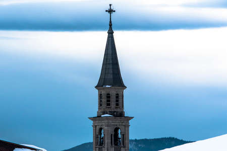bell tower with tin roof and cloudy sky in the background in Camporovere, Asiago, Vicenza, Italyの写真素材