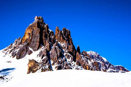 peaks of the Dolomites with snow, alpine valleys blue sky white clouds, snow tracks in the Zoldo valley, Belluno, Italyの写真素材