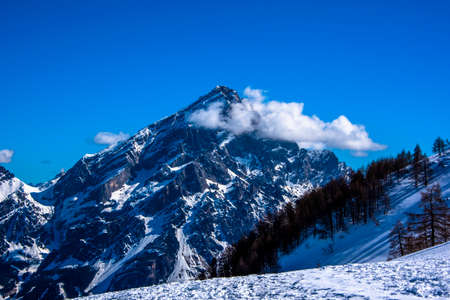 peaks of the Dolomites with snow, alpine valleys blue sky white clouds, snow tracks in the Zoldo valley, Belluno, Italyの写真素材