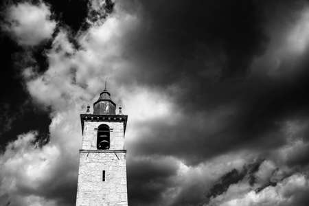 bell tower taken from below with perfectly symmetrical black and white clouds, Vicenza Italyの写真素材