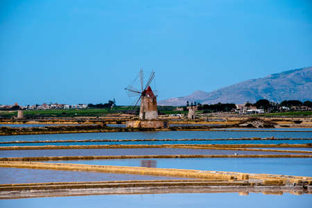 the Saline di Marsala in the Stagnone lagoon with old windmills and salt marshes in Marsala Trapani Sicily Italyの写真素材