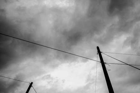 black and white photo of phone masts with threatening clouds backgroundの写真素材