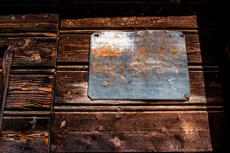 empty iron plaque on wooden door in San Martino di Castrozza Trento Italy