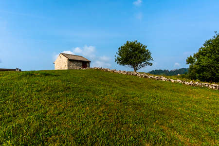 stone shelter among the green meadows on the mountains above Revine Lago Treviso Veneto Italyのeditorial素材
