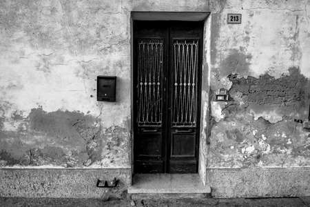 vintage door in wood and glass with wall peeling from time and rubbleの写真素材