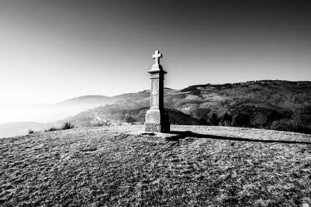 monument with stone cross on the top of the hill with the alps in the background in Lusiana Vicenza Veneto Italyの写真素材
