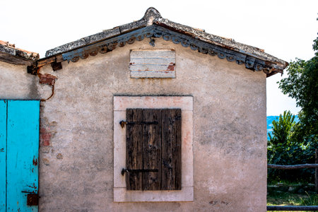 corner of Croatian village between blue sky and stone houses with blue windowsの写真素材